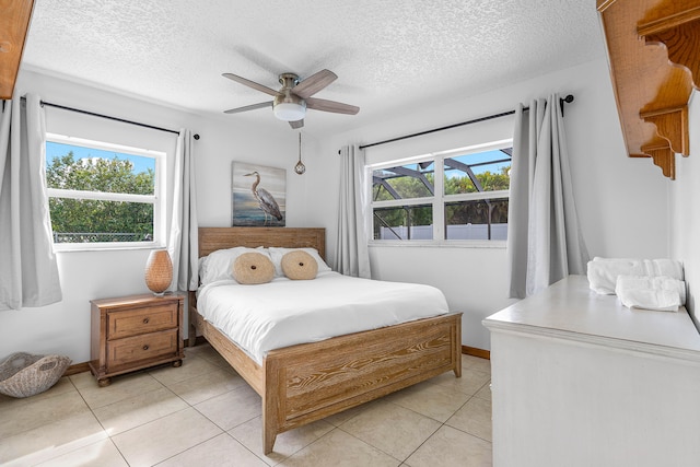 tiled bedroom featuring ceiling fan and a textured ceiling