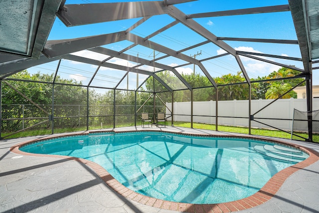 view of swimming pool with a patio and glass enclosure