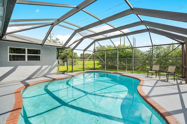 view of pool featuring a patio area, a yard, and glass enclosure