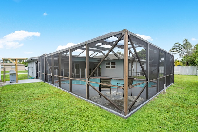 back of property featuring a fenced in pool, a patio area, a lanai, and a yard