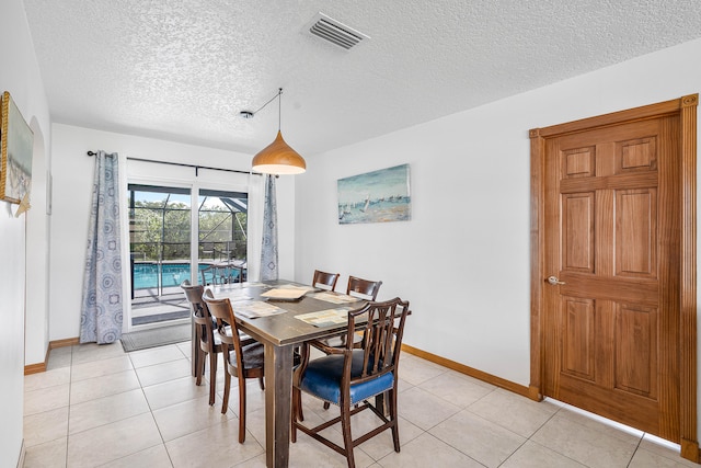 tiled dining area with a textured ceiling