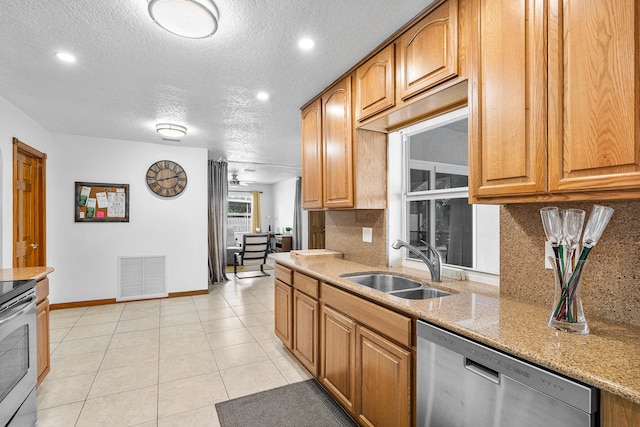 kitchen with decorative backsplash, light stone counters, appliances with stainless steel finishes, a textured ceiling, and sink