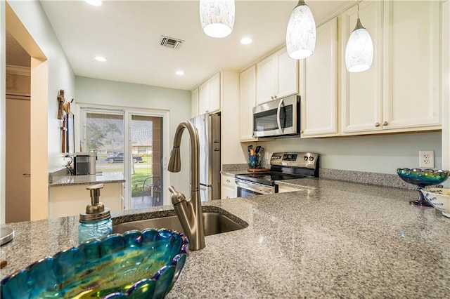 kitchen with white cabinetry, light stone countertops, stainless steel appliances, and hanging light fixtures