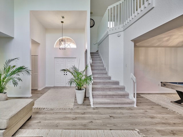 foyer with a notable chandelier, a high ceiling, and light wood-type flooring