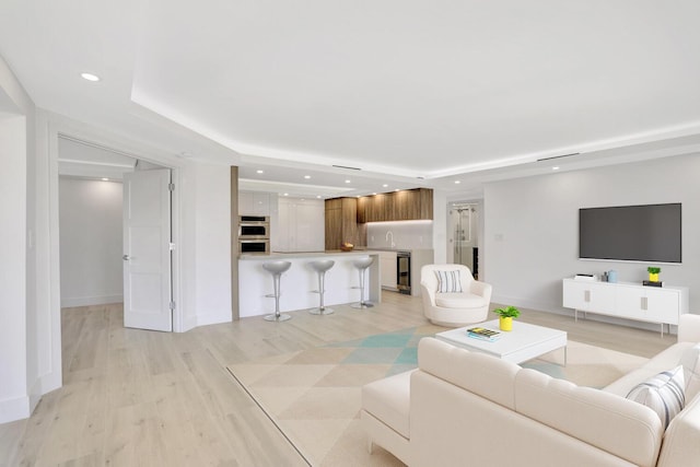600 S Ocean Blvd Unit 103, Boca Raton, FL 33432 - living room with recessed lighting, a tray ceiling, baseboards, light wood-type flooring, and wine cooler