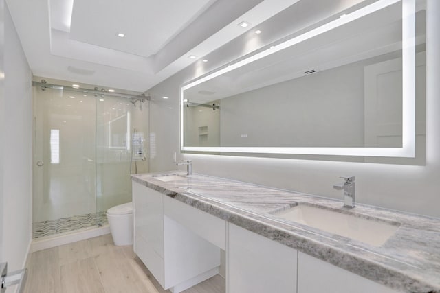 bathroom featuring vanity, toilet, and an enclosed shower