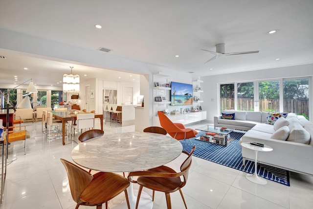 interior space featuring ceiling fan with notable chandelier and light tile patterned floors