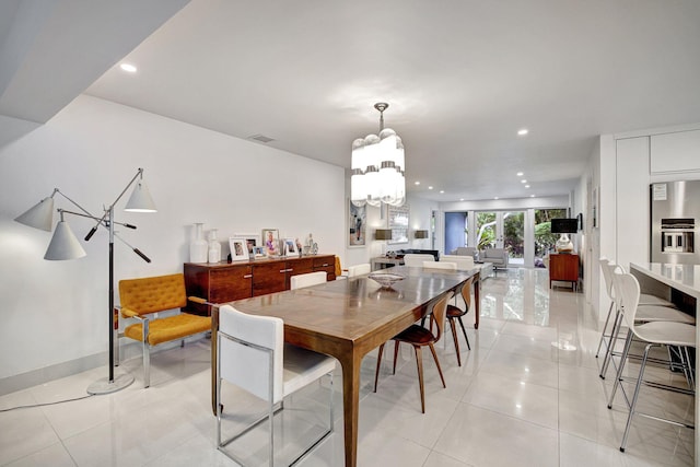 tiled dining space with an inviting chandelier