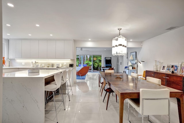 dining room with a chandelier, sink, and light tile patterned floors