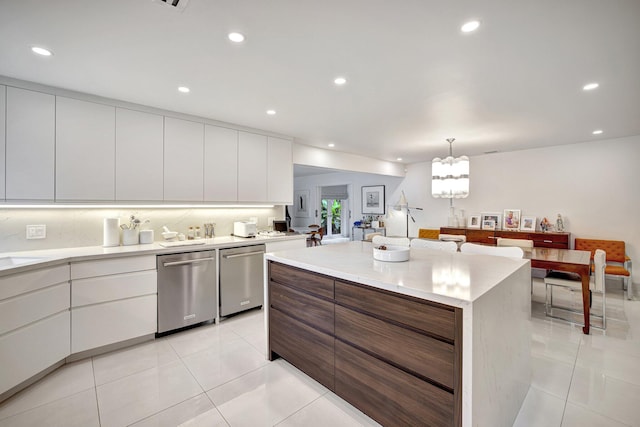 kitchen featuring white cabinets, stainless steel dishwasher, hanging light fixtures, and a kitchen island