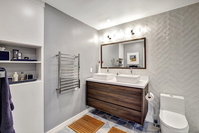 bathroom with radiator, tile walls, toilet, vanity, and tile patterned floors