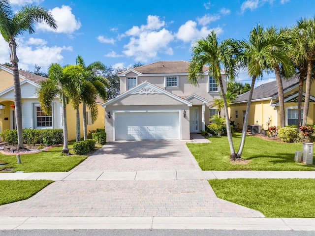 view of front of home featuring a garage, a front yard, and central AC