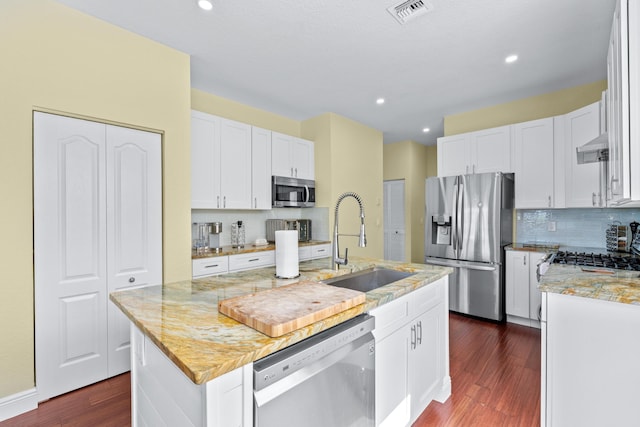 kitchen featuring dark hardwood / wood-style flooring, sink, a kitchen island with sink, white cabinetry, and appliances with stainless steel finishes