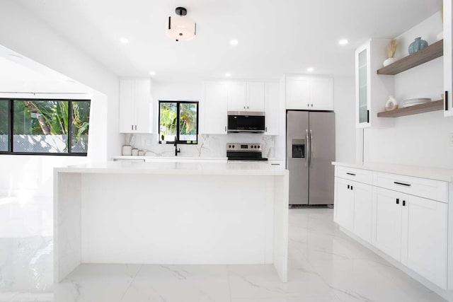 kitchen with sink, backsplash, a center island, stainless steel appliances, and white cabinets