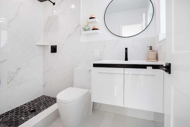 bathroom featuring a tile shower, tile walls, toilet, vanity, and tile patterned flooring