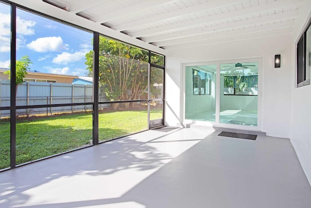 unfurnished sunroom featuring beam ceiling, plenty of natural light, and ceiling fan