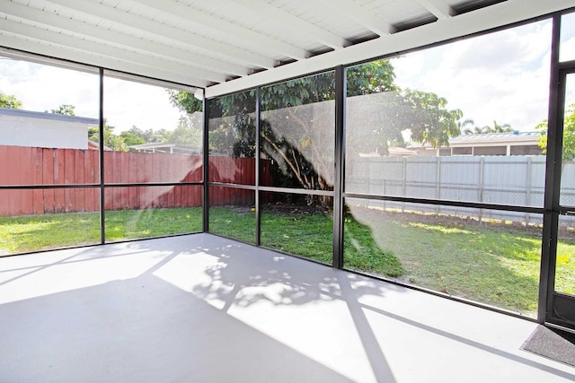 unfurnished sunroom with beamed ceiling