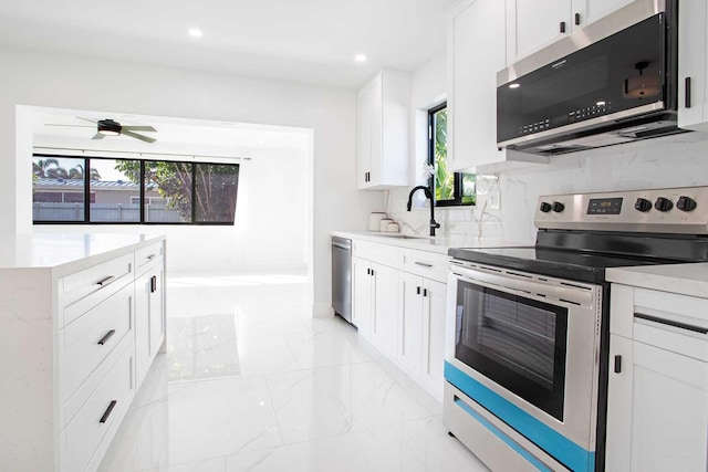 kitchen with a wealth of natural light, white cabinets, and stainless steel appliances