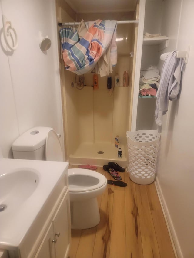 bathroom featuring walk in shower, sink, toilet, and hardwood / wood-style floors