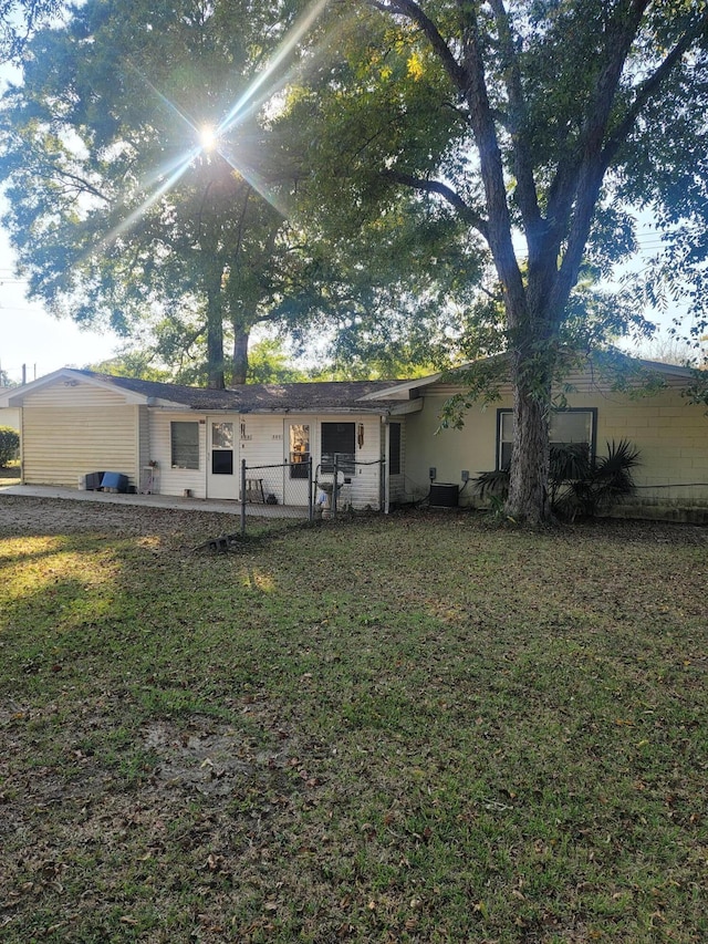 back of property with central AC and a yard