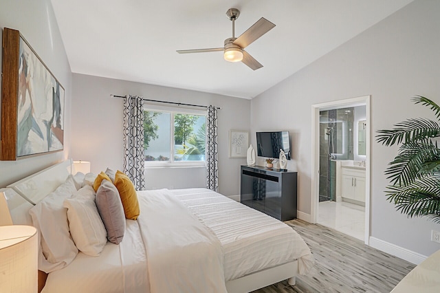 bedroom with ensuite bath, ceiling fan, vaulted ceiling, and light hardwood / wood-style flooring