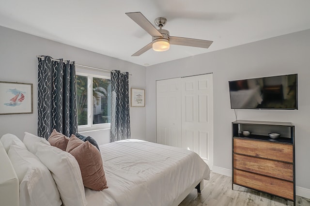 bedroom featuring light hardwood / wood-style floors, ceiling fan, and a closet