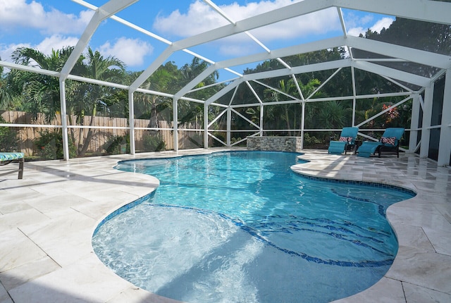 view of swimming pool featuring a lanai and a patio area