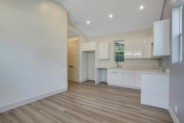 kitchen featuring white cabinetry, high vaulted ceiling, light hardwood / wood-style flooring, and sink