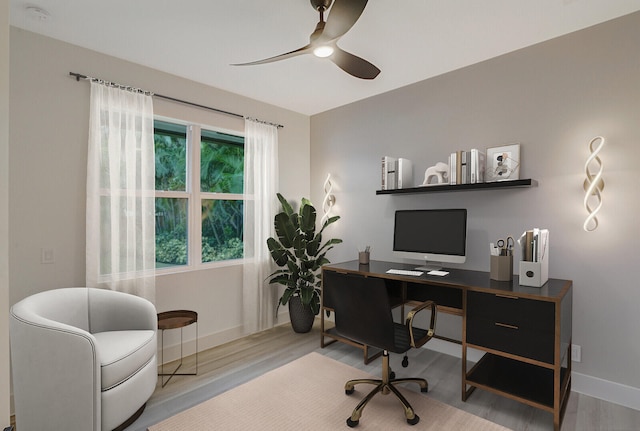 home office with light wood-type flooring and ceiling fan