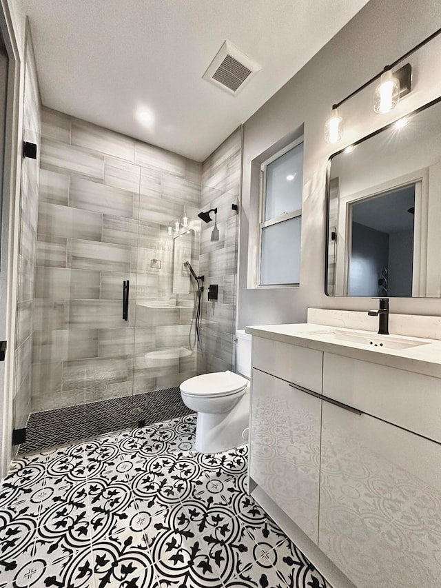 bathroom featuring a textured ceiling, vanity, an enclosed shower, tile patterned floors, and toilet