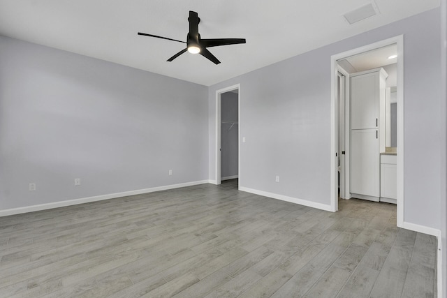 spare room with ceiling fan and light wood-type flooring