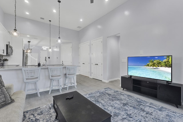 living room featuring light hardwood / wood-style floors and a high ceiling