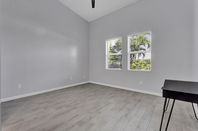 spare room with ceiling fan, light hardwood / wood-style floors, and high vaulted ceiling