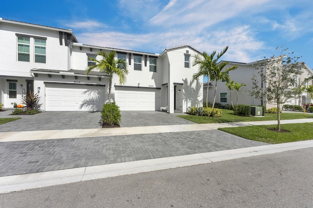 view of front of home with a garage and cooling unit