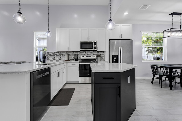 kitchen with white cabinets, hanging light fixtures, appliances with stainless steel finishes, and sink