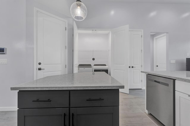 kitchen featuring washer and dryer, decorative light fixtures, dishwasher, a kitchen island, and white cabinets