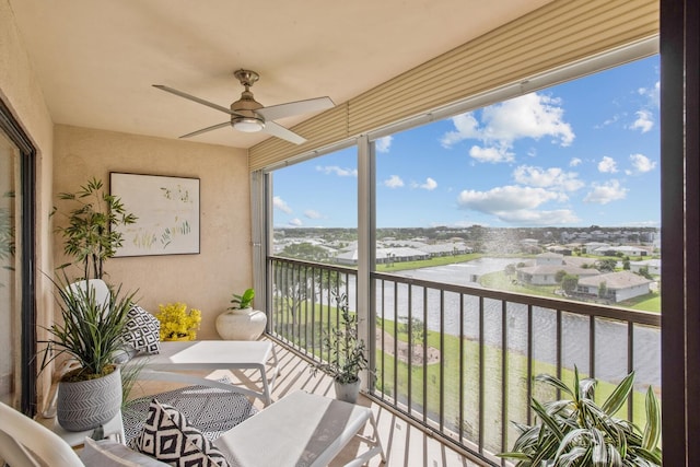 balcony with a water view and ceiling fan