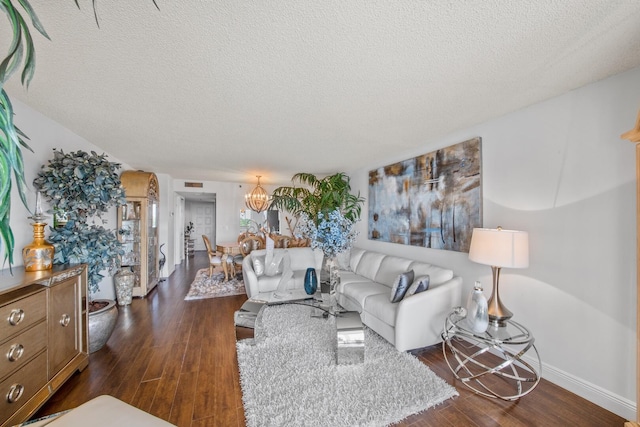 living room featuring a chandelier, a textured ceiling, and dark hardwood / wood-style flooring