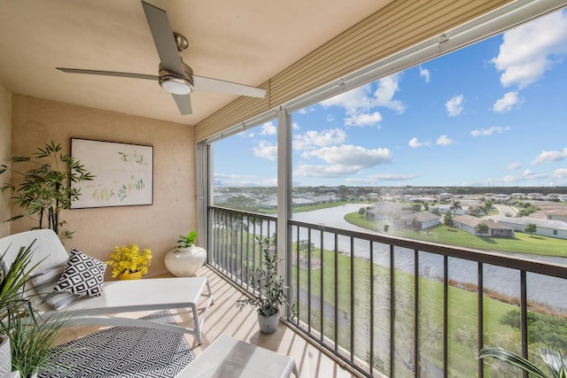 balcony featuring a water view and ceiling fan