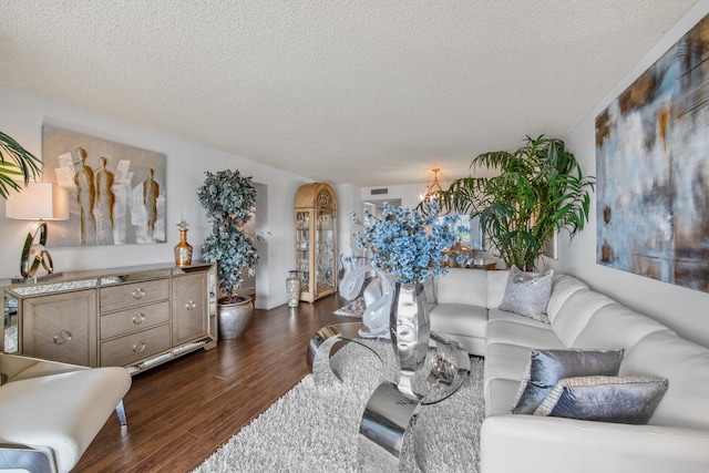 living room featuring dark wood-type flooring, a notable chandelier, and a textured ceiling