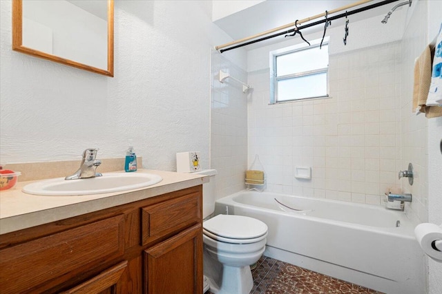 full bathroom with vanity, tiled shower / bath combo, and toilet