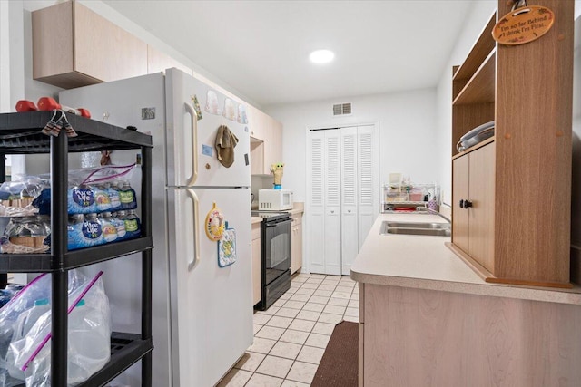 kitchen with black range with electric cooktop, light brown cabinetry, sink, and light tile patterned floors