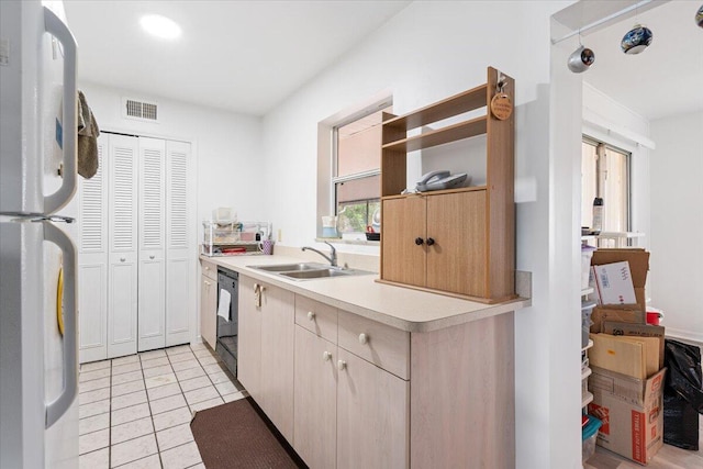 kitchen with dishwasher, light brown cabinets, sink, light tile patterned floors, and white fridge