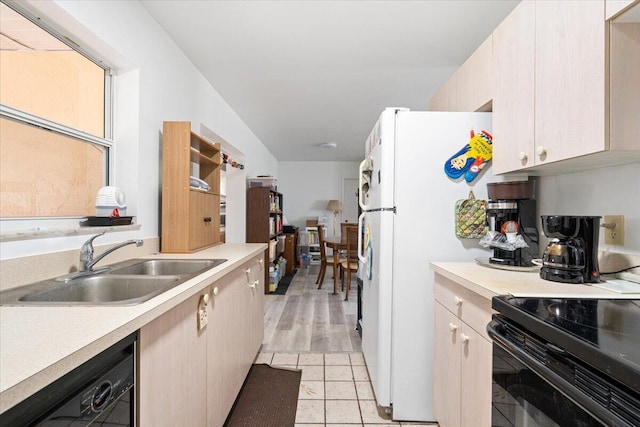 kitchen featuring light brown cabinetry, light tile patterned flooring, black appliances, and sink