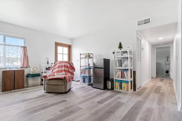 living area with a healthy amount of sunlight and light wood-type flooring