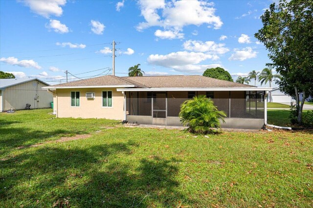 back of house with a lawn and a sunroom