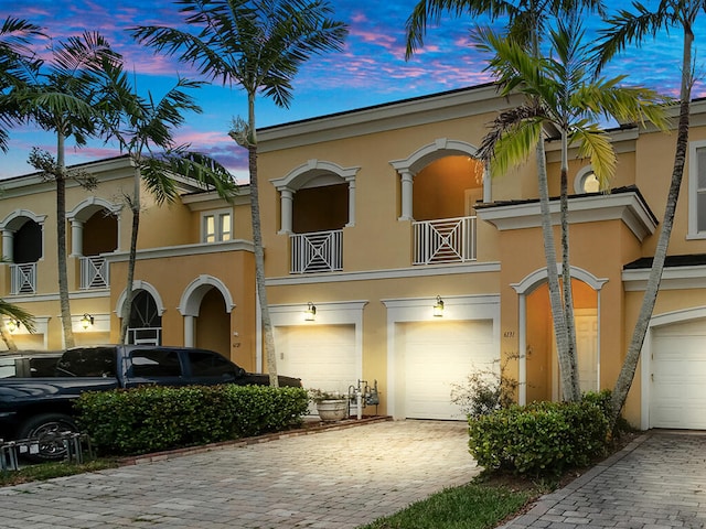 view of front facade featuring a garage and a balcony