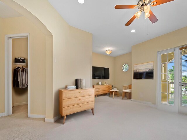 interior space with a spacious closet, a closet, access to exterior, and ceiling fan