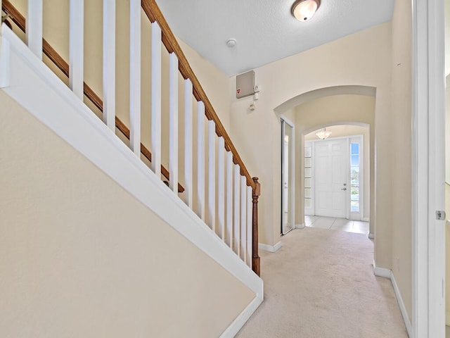 carpeted entryway featuring a textured ceiling