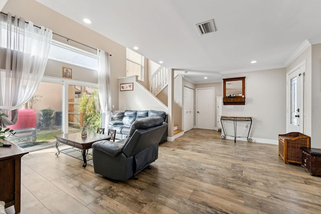 living room featuring ornamental molding and light wood-type flooring